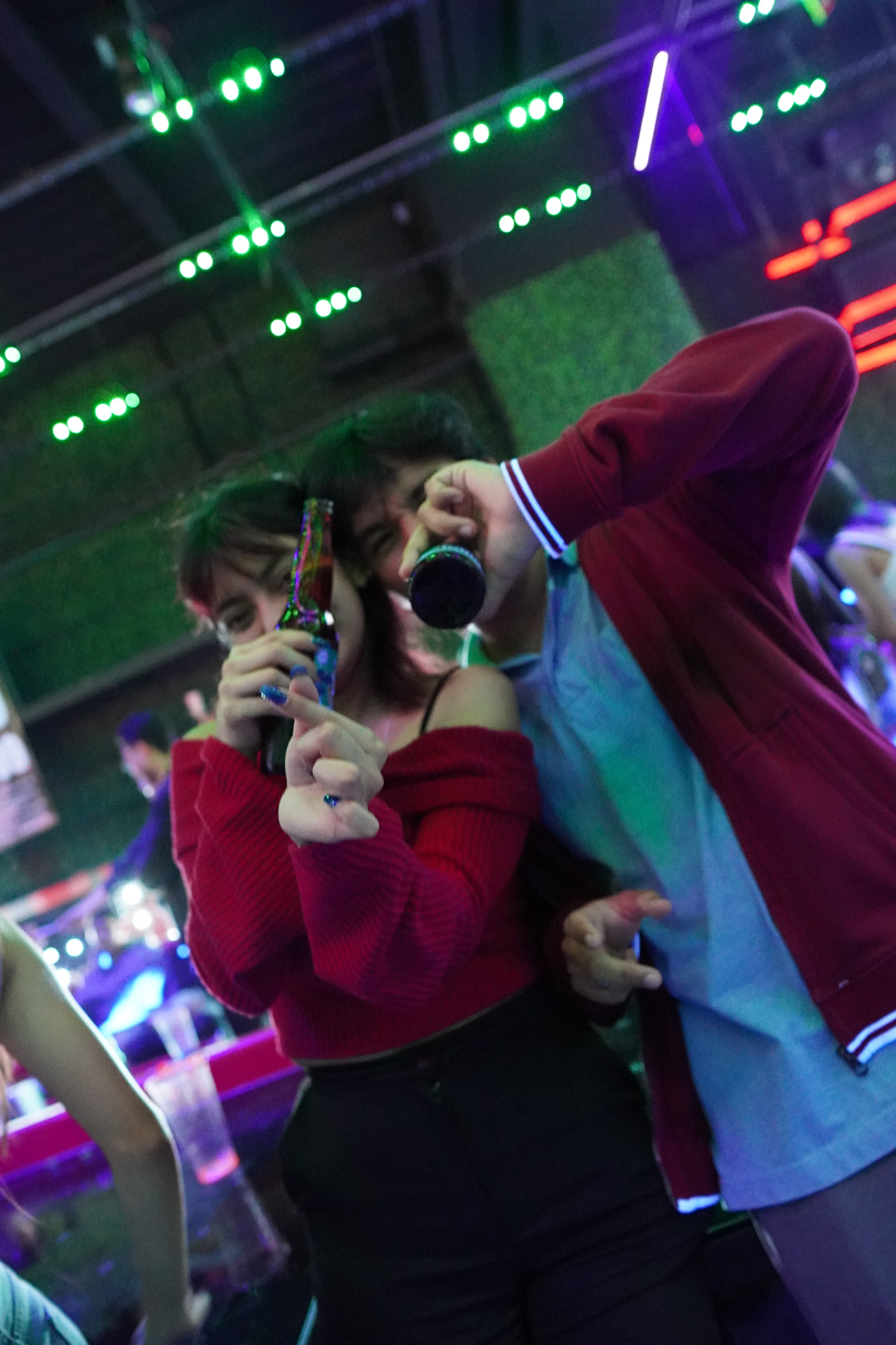 The interior of a bar with people sitting at tables, with a vibrant, energetic atmosphere.